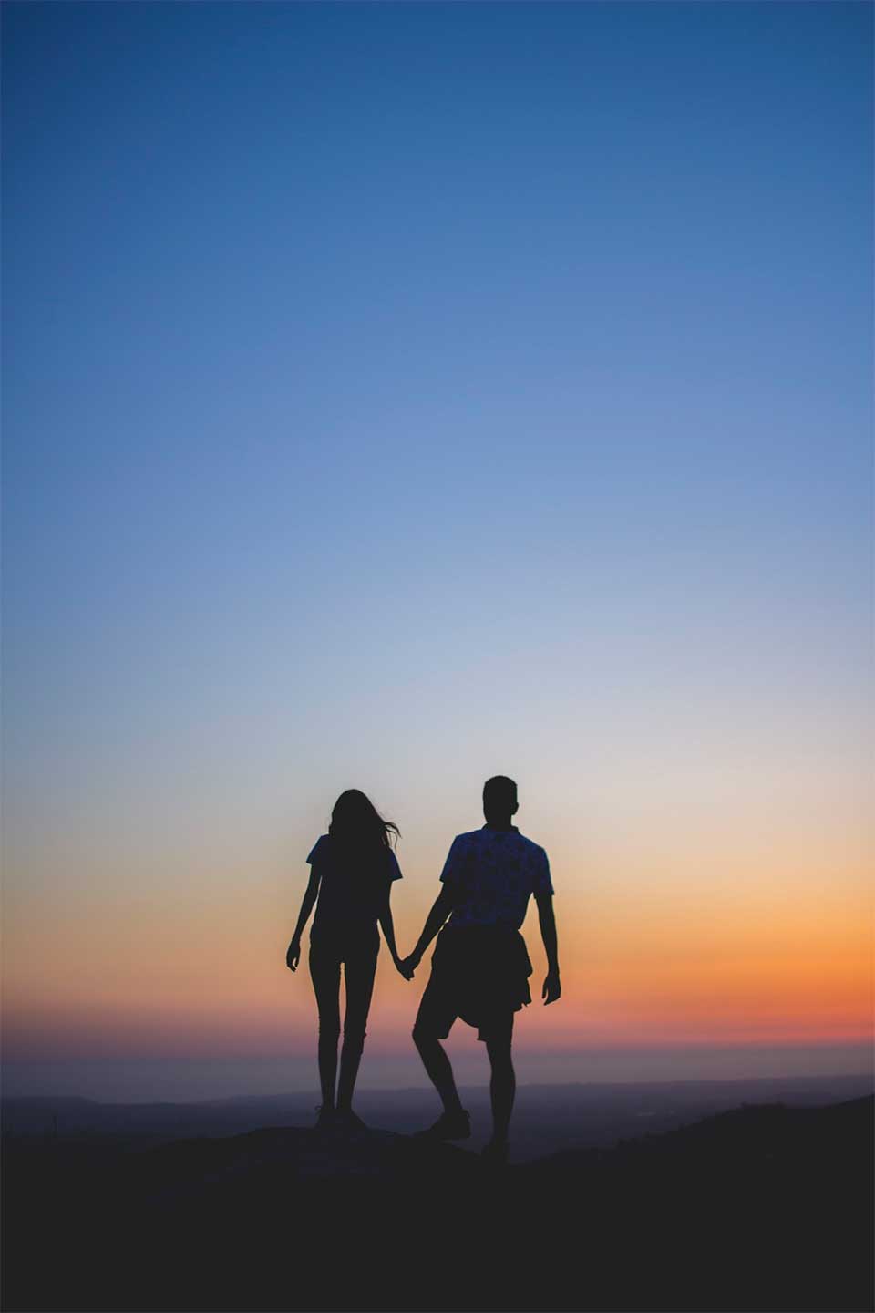 Two people walking outdoors at sunset